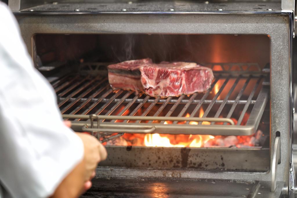 BO Hotel Palma Kültér fotó A steak being cooked on a barbecue